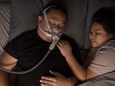 Uomo che dorme comodamente con il dispositivo CPAP ResMed