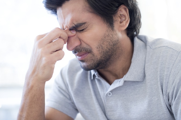  Uomo che si sfrega la radice del naso