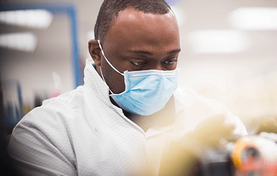 Uomo con maschera che lavora in laboratorio