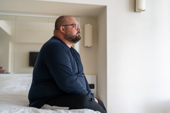  Uomo irrequieto seduto sul letto